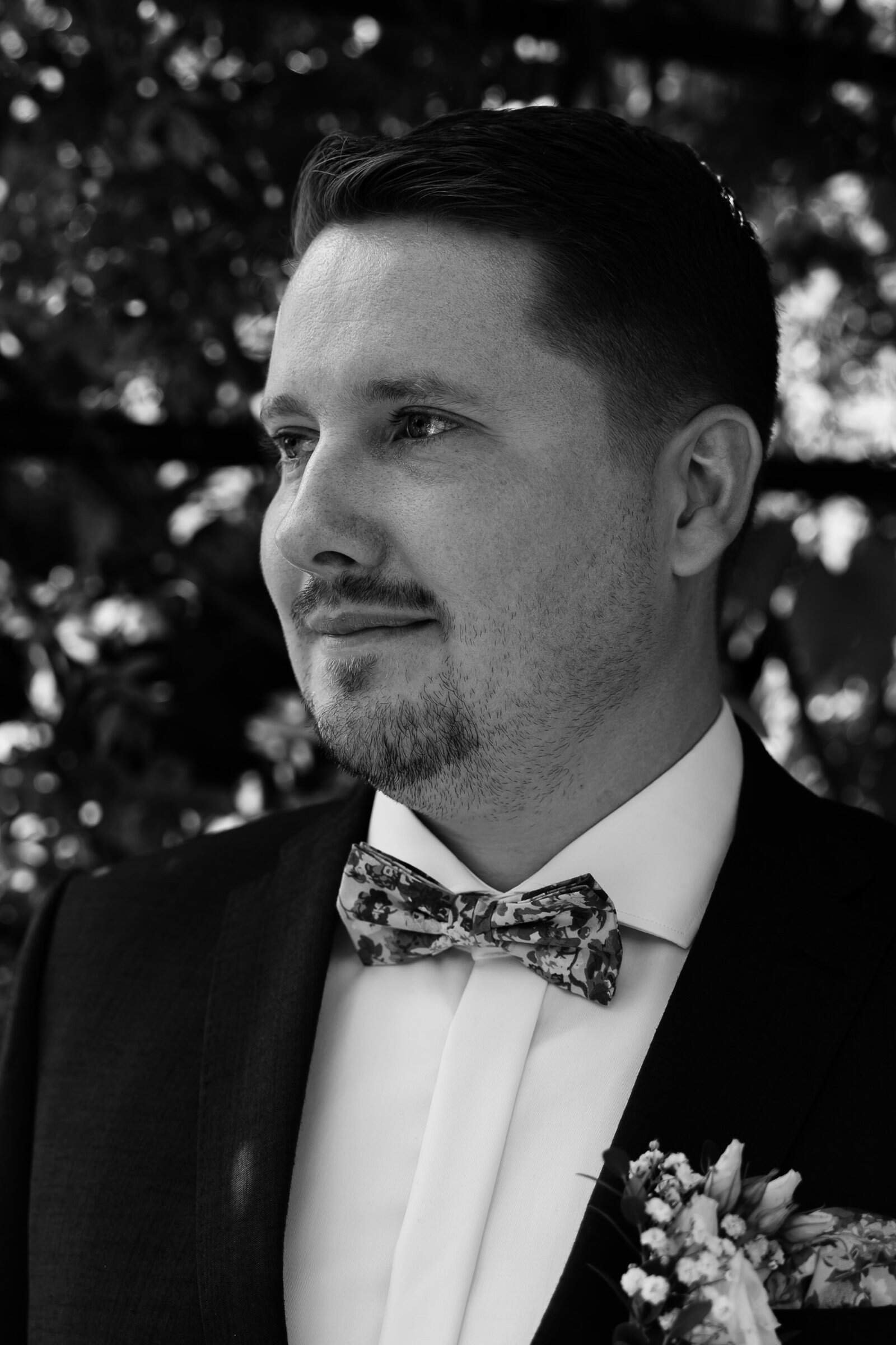 Ein überwältigter Bräutigam wartet bei seiner freien Trauung in Starnberg auf die Braut, Schwarz-Weiß-Hochzeitsfotografie.