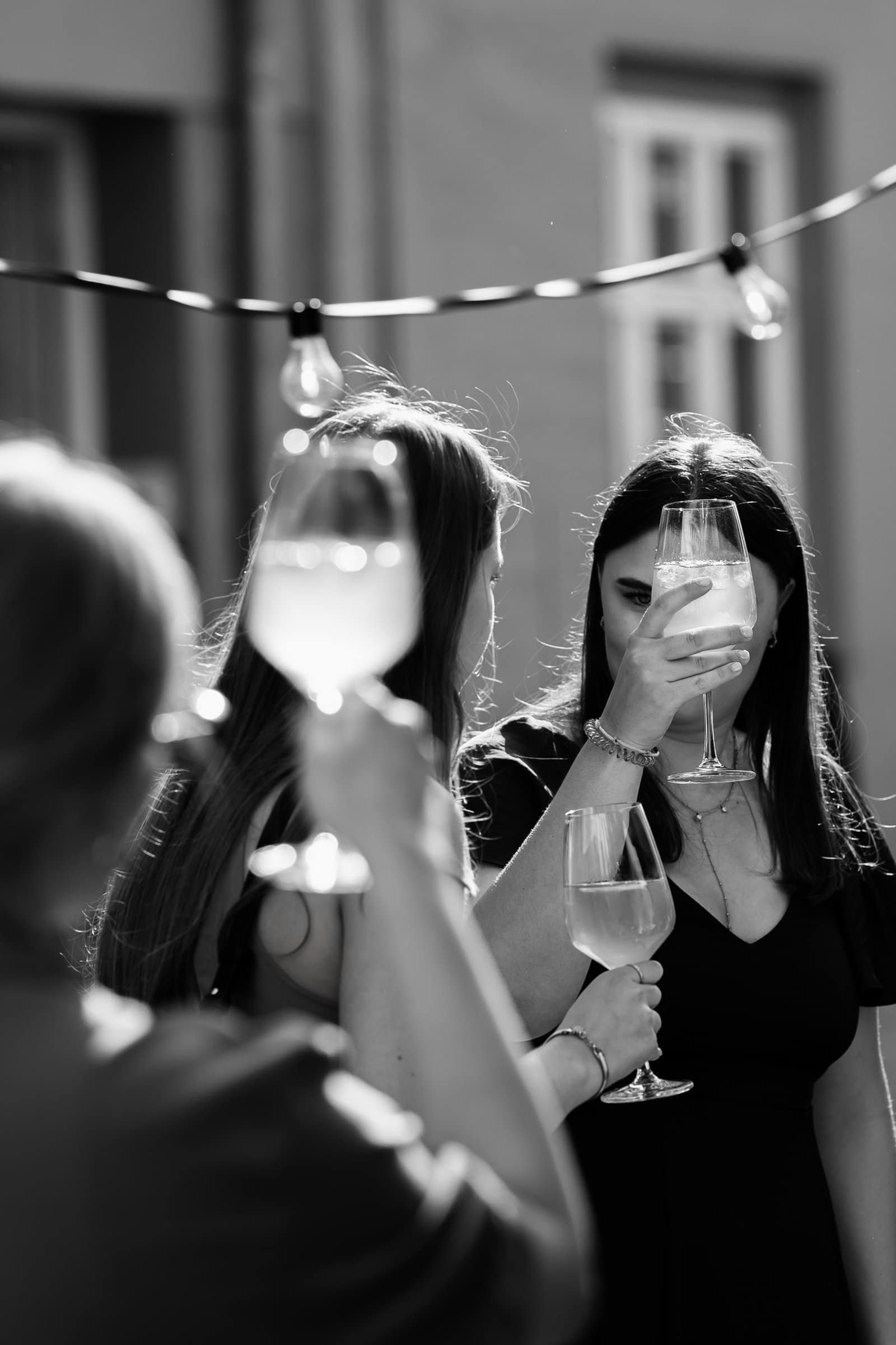 Hochzeitsgäste stoßen mit Drinks auf der urbanen Hochzeitsfeier in München an.