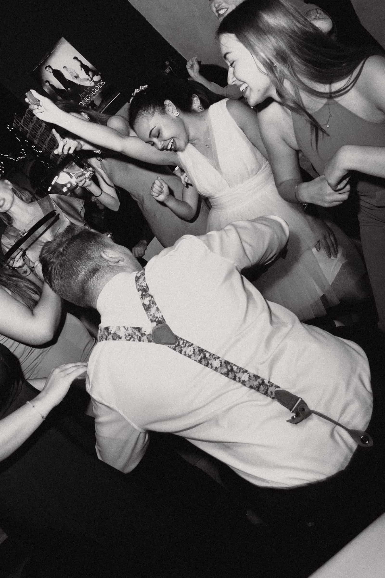 Wilde Partystimmung und tanzende Gäste auf der Hochzeitsfeier in München, künstlerische Schwarz-Weiß-Aufnahme.